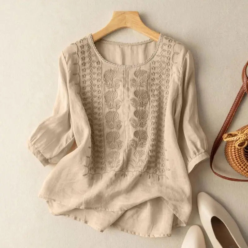 Close-up view of embroidered floral and geometric detailing on women's linen blouse front bodice