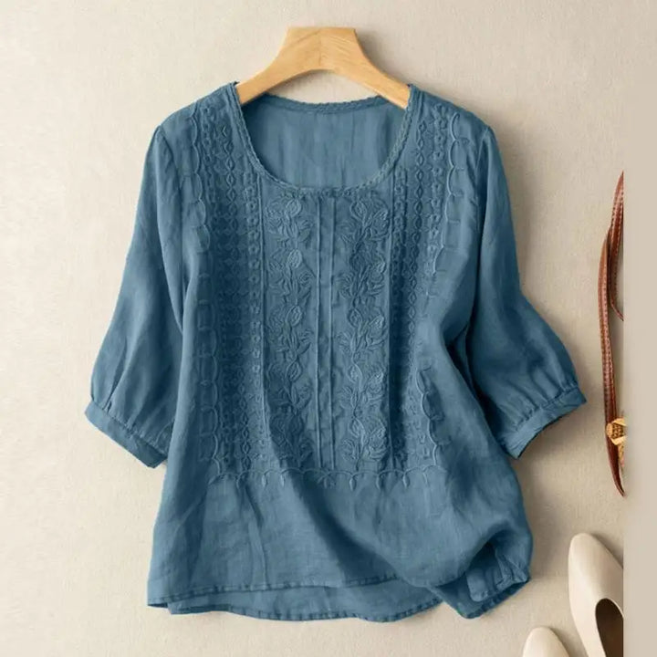 Side angle of relaxed fit linen blouse showing curved hem and rolled cuff sleeves