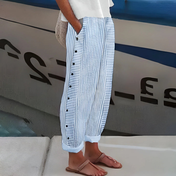 Woman wearing women's striped cropped pants with vertical panel and button detail on boat deck