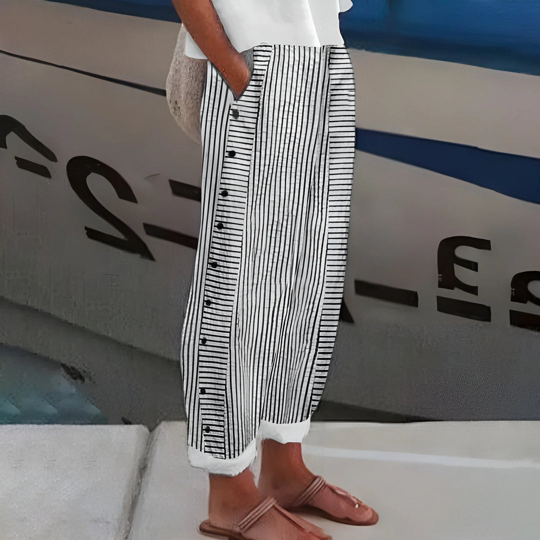 Close-up view of women's cropped pants showing vertical striped panel with decorative button accents