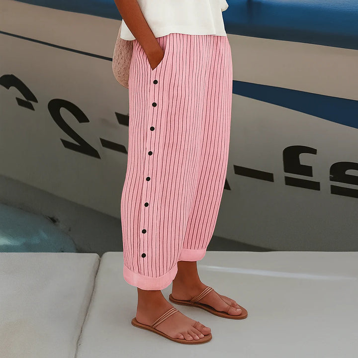 Full length view of women's mid-rise cropped pants with side pockets and button detail