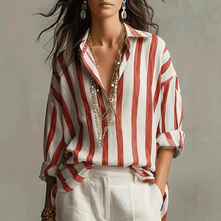 Side view of women's long sleeve striped shirt with loose flowy silhouette and roll-tab sleeves