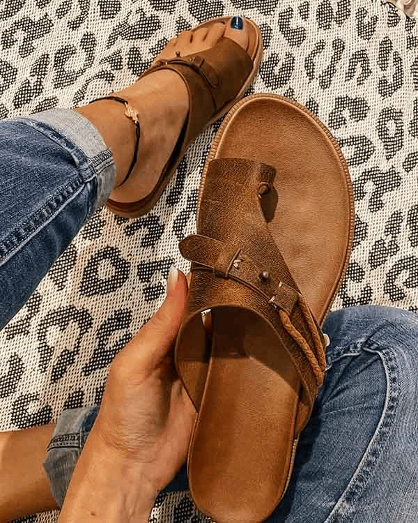 Side angle of women's comfort sandals displaying molded footbed and adjustable toe loop strap
