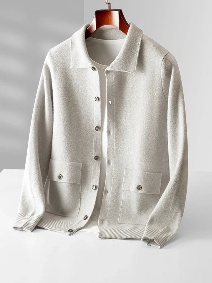 Men's button-up polo cardigan in cream with ribbed cuffs and dual chest pockets displayed on hanger