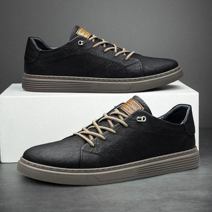 Side view of men's black textured sneakers with contrast tan accents and padded collar