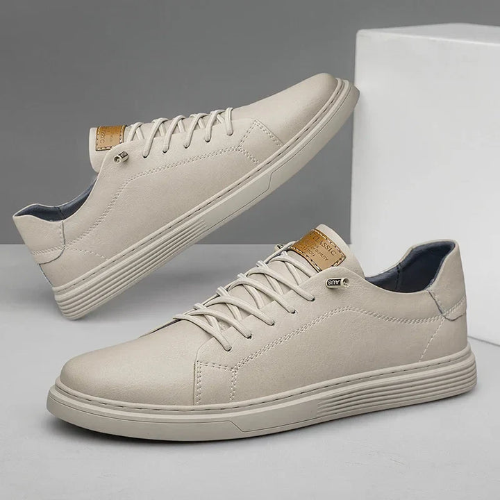Top-down view of men's black lace-up sneakers with tan eyelets and textured upper