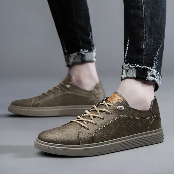 Full view of men's black court sneakers with tan lace accents and flexible sole