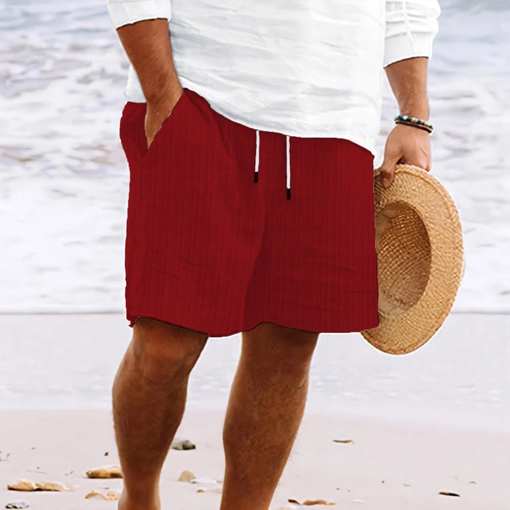 Men's knee-length chino shorts in white showing vertical stripe pattern and loose comfortable fit