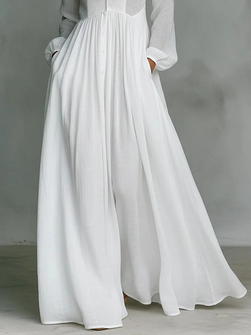 Back view of flowing white maxi dress with long sleeves and ankle-grazing hem for casual elegance
