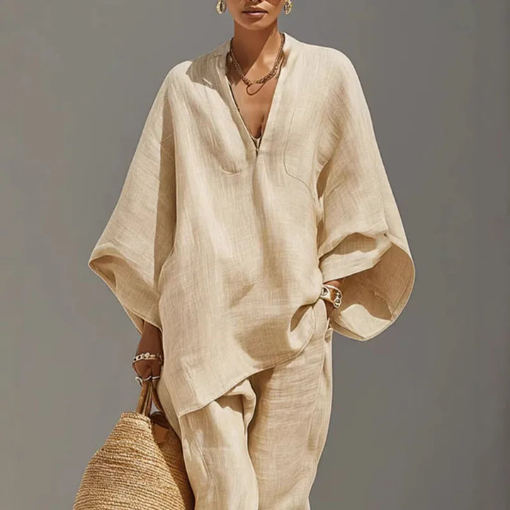 Woman wearing beige linen matching set with batwing sleeve top and tapered pants in natural light