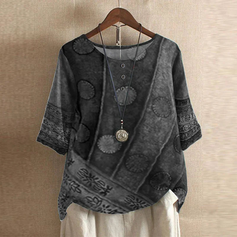 Close detail of vintage floral embroidery pattern on women's loose fit blouse in muted tones