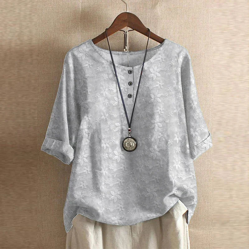 Detail of floral embroidery pattern and soft fabric drape on women's casual blouse