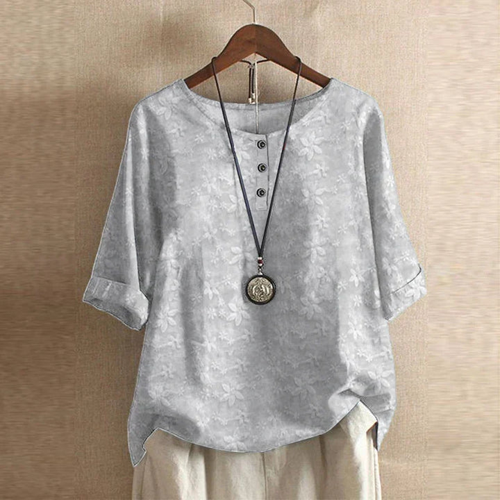 Detail of floral embroidery pattern and soft fabric drape on women's casual blouse