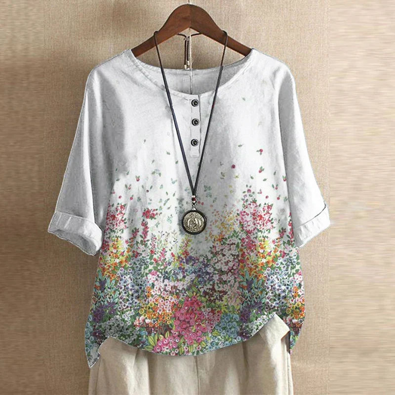 Women's floral print blouse styled with white pants showing versatile casual look