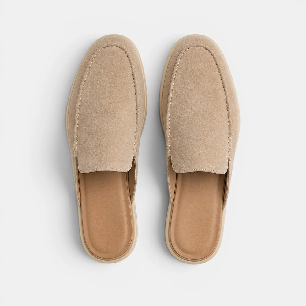 Side view of men's beige suede mules showing contrast stitching and rounded toe silhouette