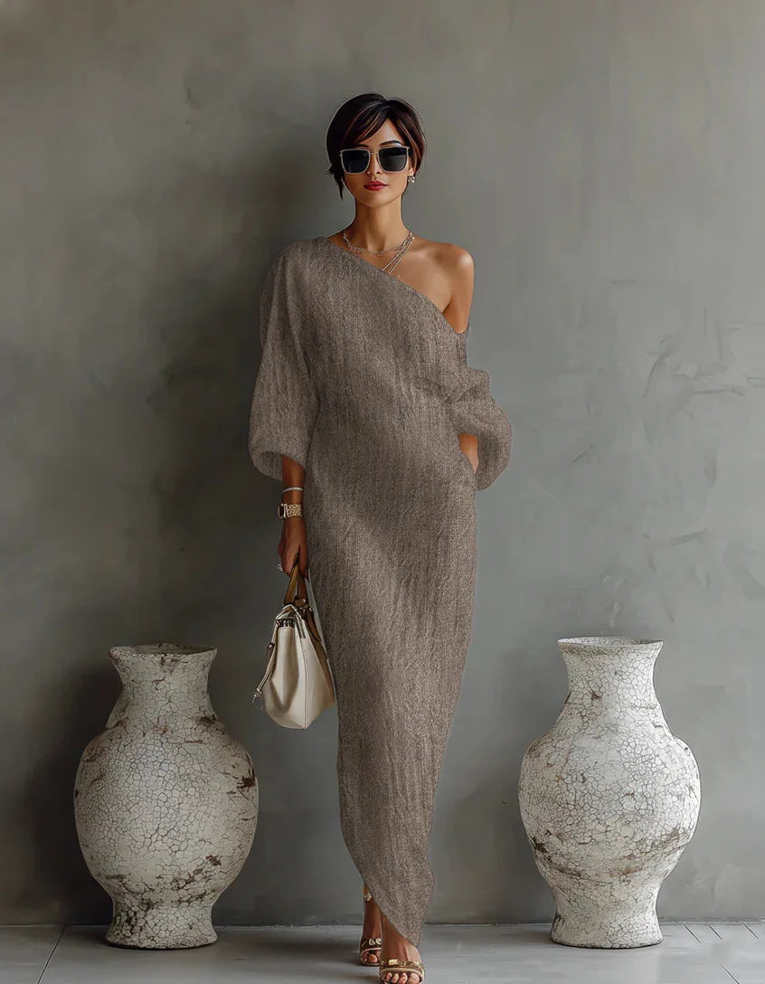 Close-up of one shoulder neckline and batwing sleeve detail on linen dress with soft drape
