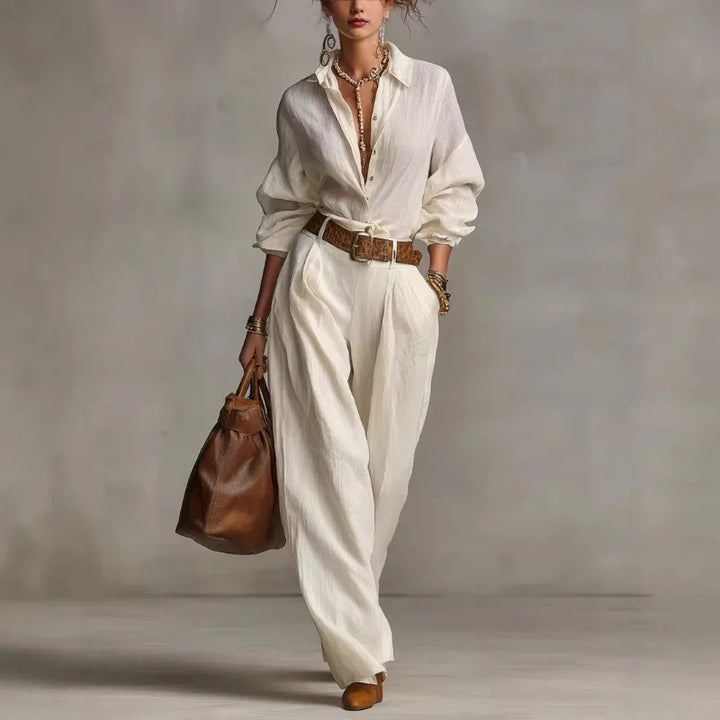 Woman wearing a white button-down two-piece lounge set with wide-leg pants and a relaxed shirt
