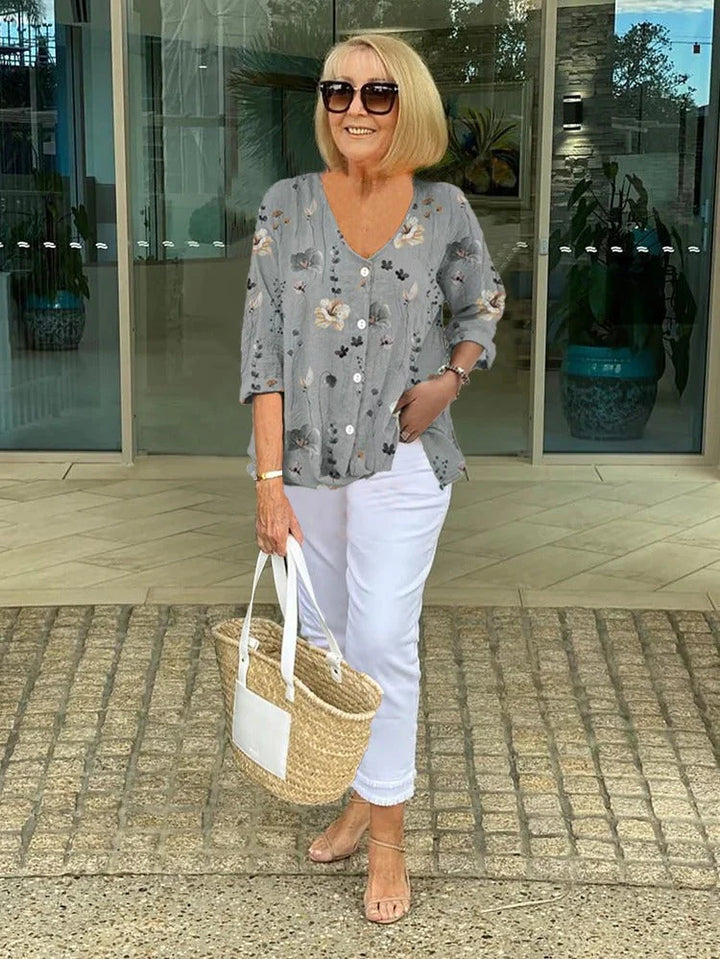 Neutral floral blouse with V-neckline and relaxed fit for versatile layering.