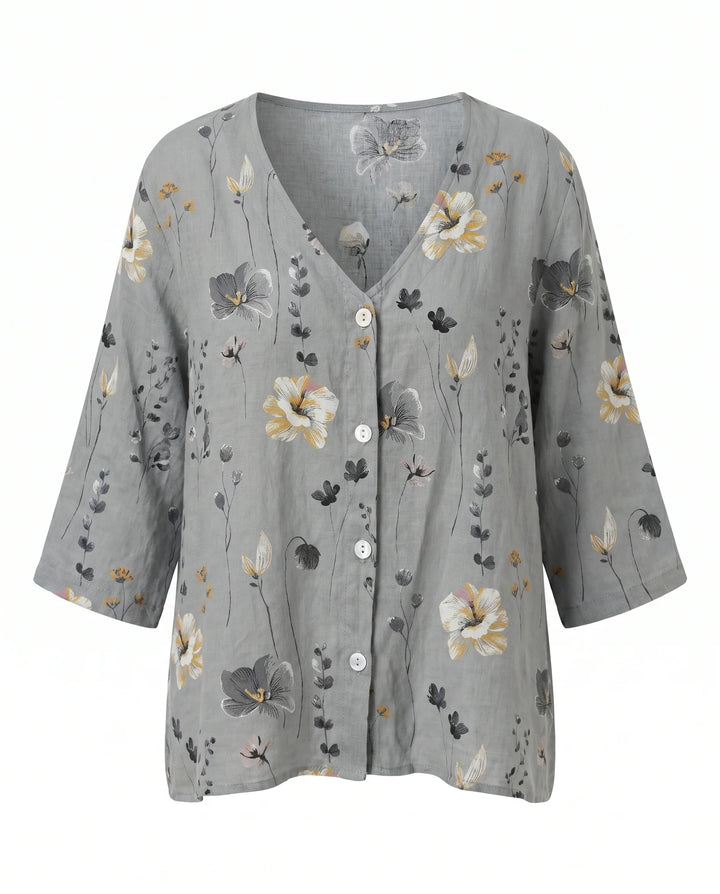 Three-quarter sleeve floral blouse with button-front closure and loose drape.