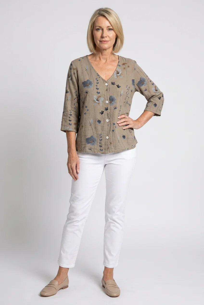 Relaxed fit floral blouse with scattered blue and gray floral print on neutral base.