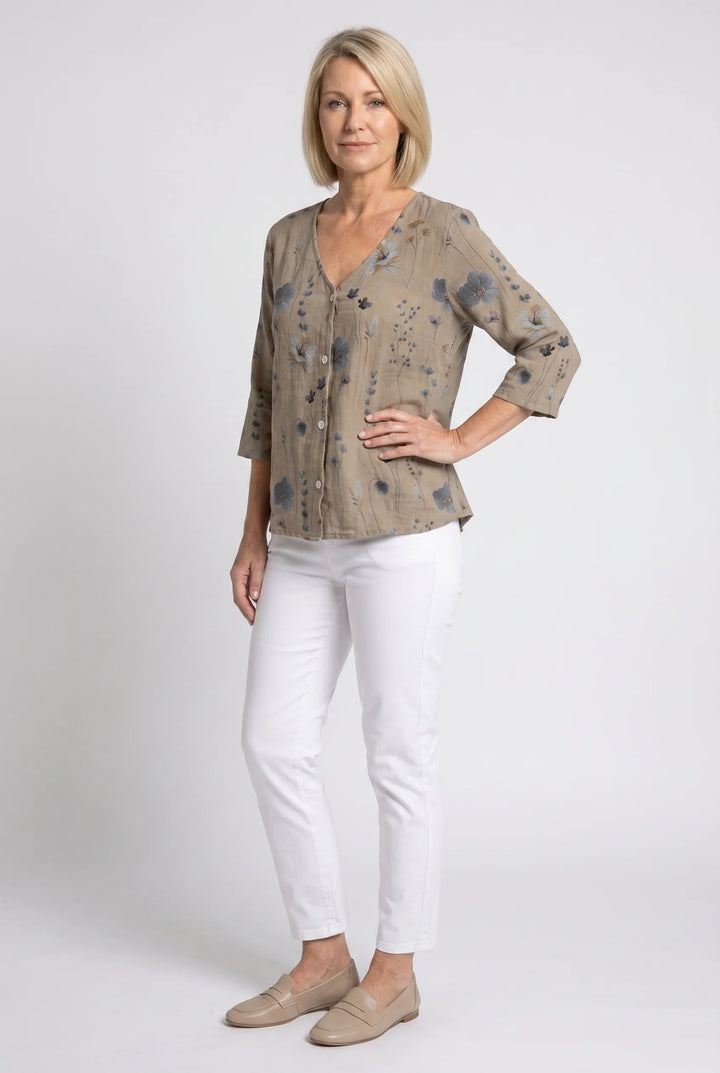Three-quarter sleeve V-neck blouse styled with white pants and woven tote bag.
