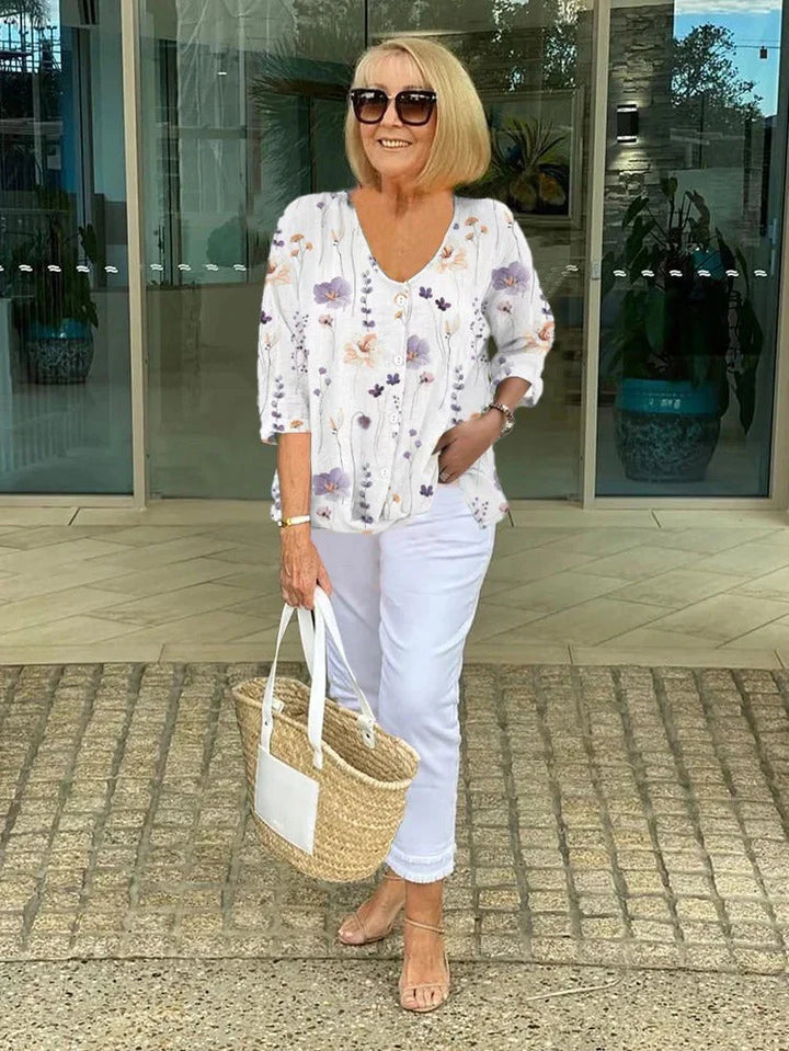 Women's button-front blouse with scattered floral print and draped fit.