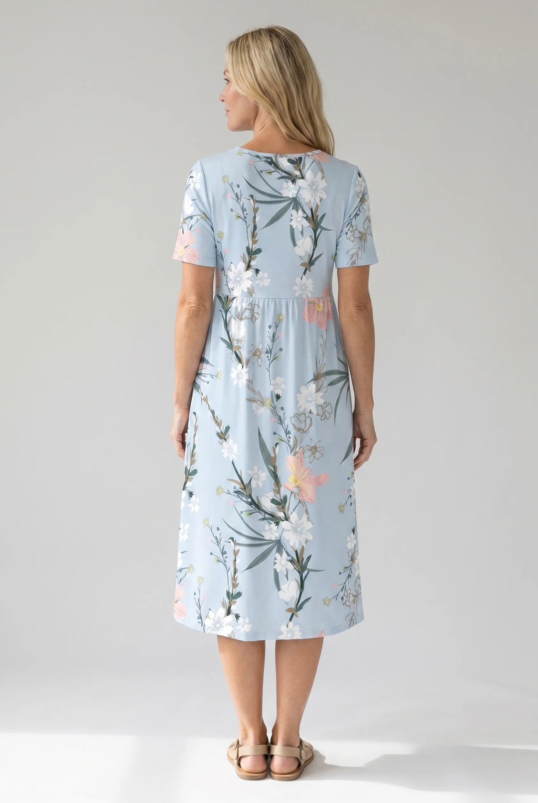 Detail shot of botanical floral print with white flowers and green foliage on midi dress