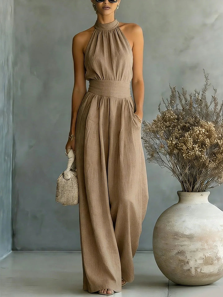 Full length halter wide leg jumpsuit styled for vacation wear with strappy sandals