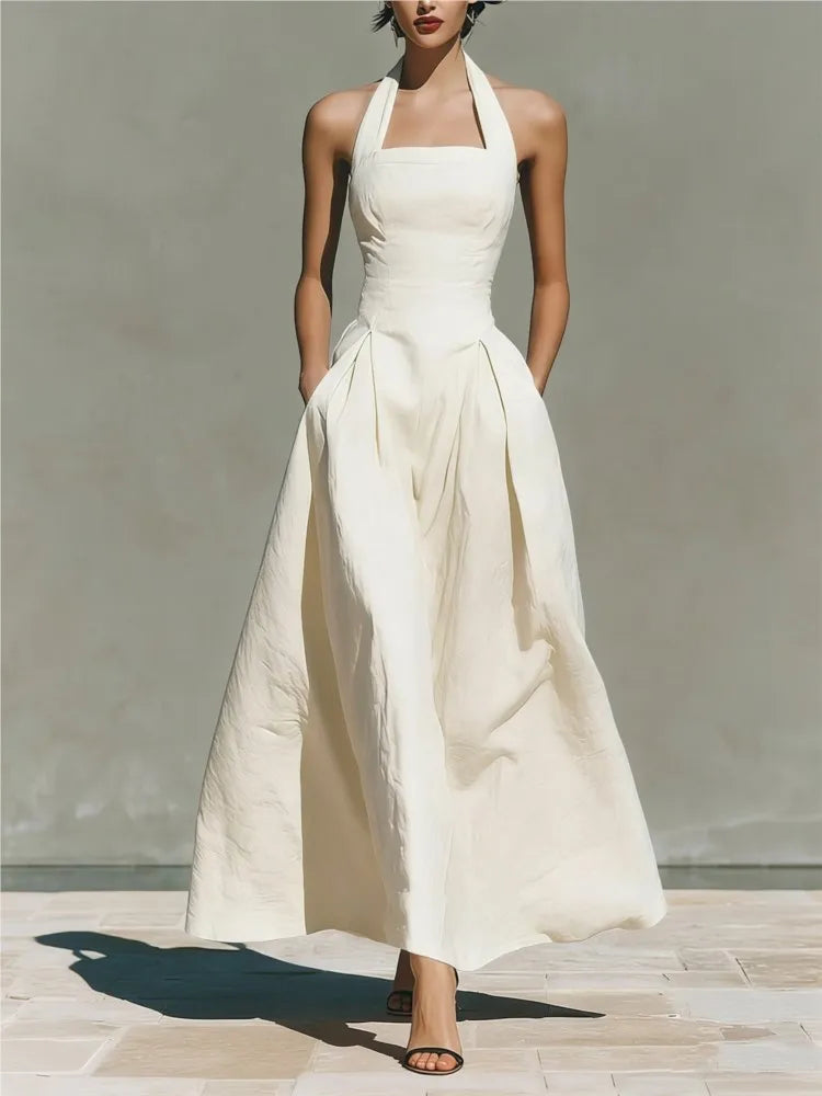 Detail shot of pleated skirt and waist seam on halter maxi dress