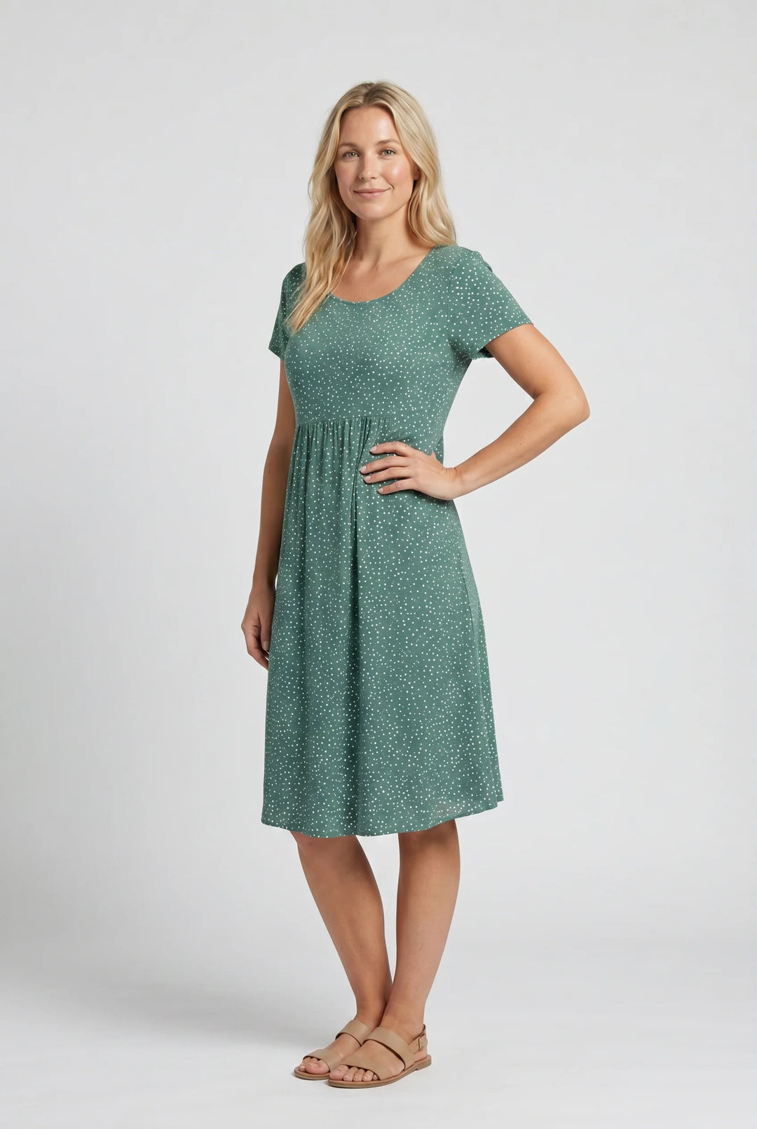 Side view of teal polka dot midi dress displaying flowing A-line shape and knee-length hem