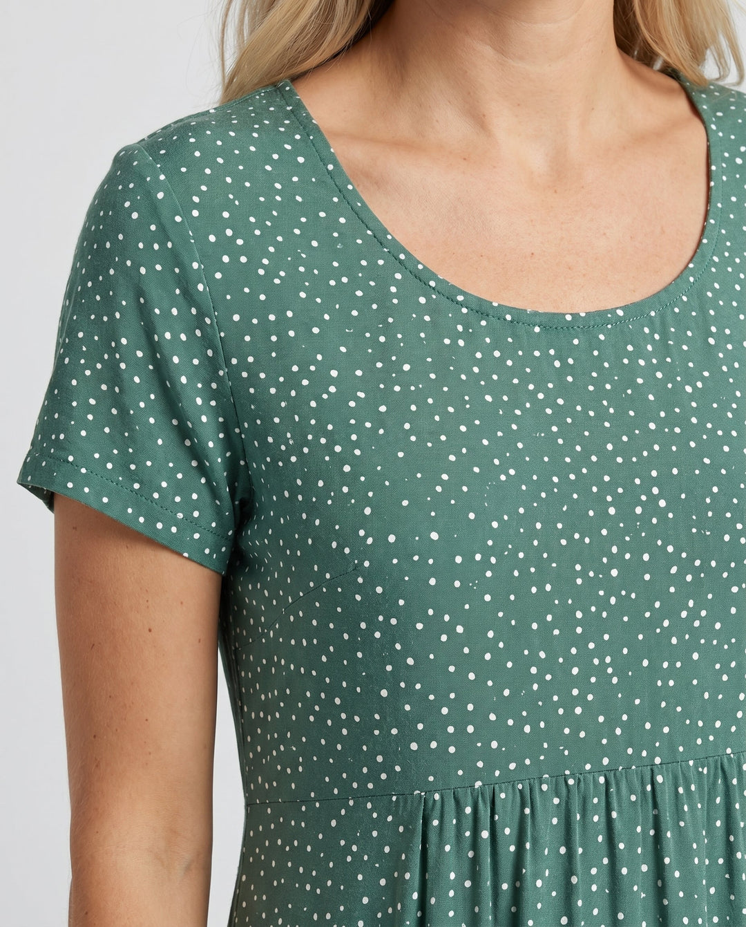 Woman styling polka dot midi dress with casual accessories for everyday summer wear