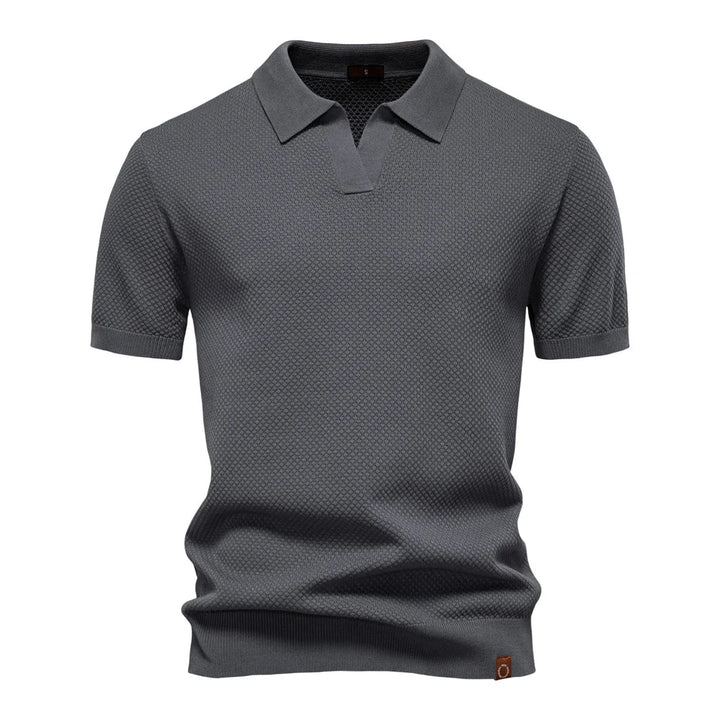 Side angle of men's short-sleeve knit polo with classic collar and ribbed cuffs