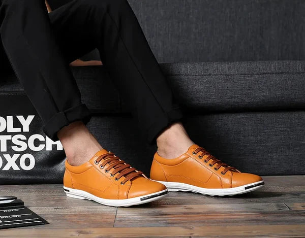 Close-up of men's low-top sneakers showing smooth finish and metal eyelets for laces