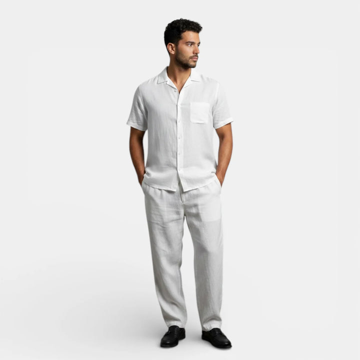 Back view of men's black short sleeve shirt with center pleat and curved hem