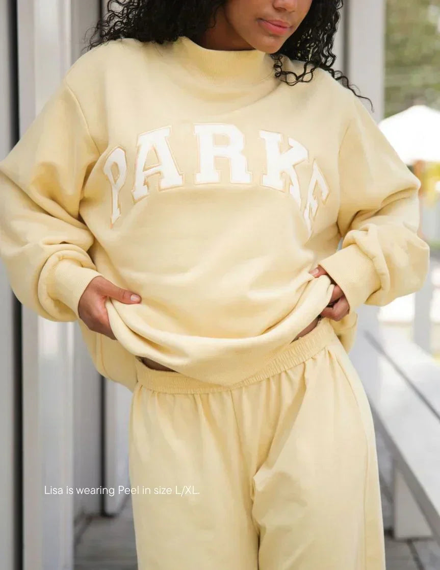 White varsity sweatshirt with navy chenille lettering and crewneck collar