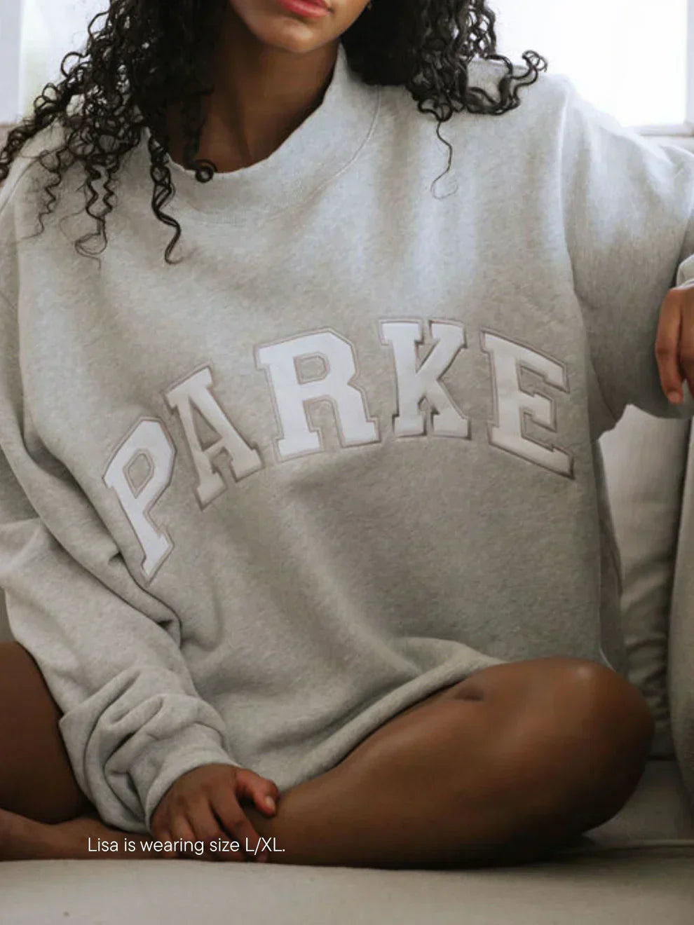 Navy varsity sweatshirt with red chenille letters in oversized collegiate style