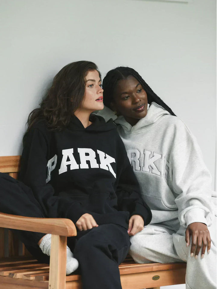 Black varsity sweatshirt with white chenille lettering in oversized fit