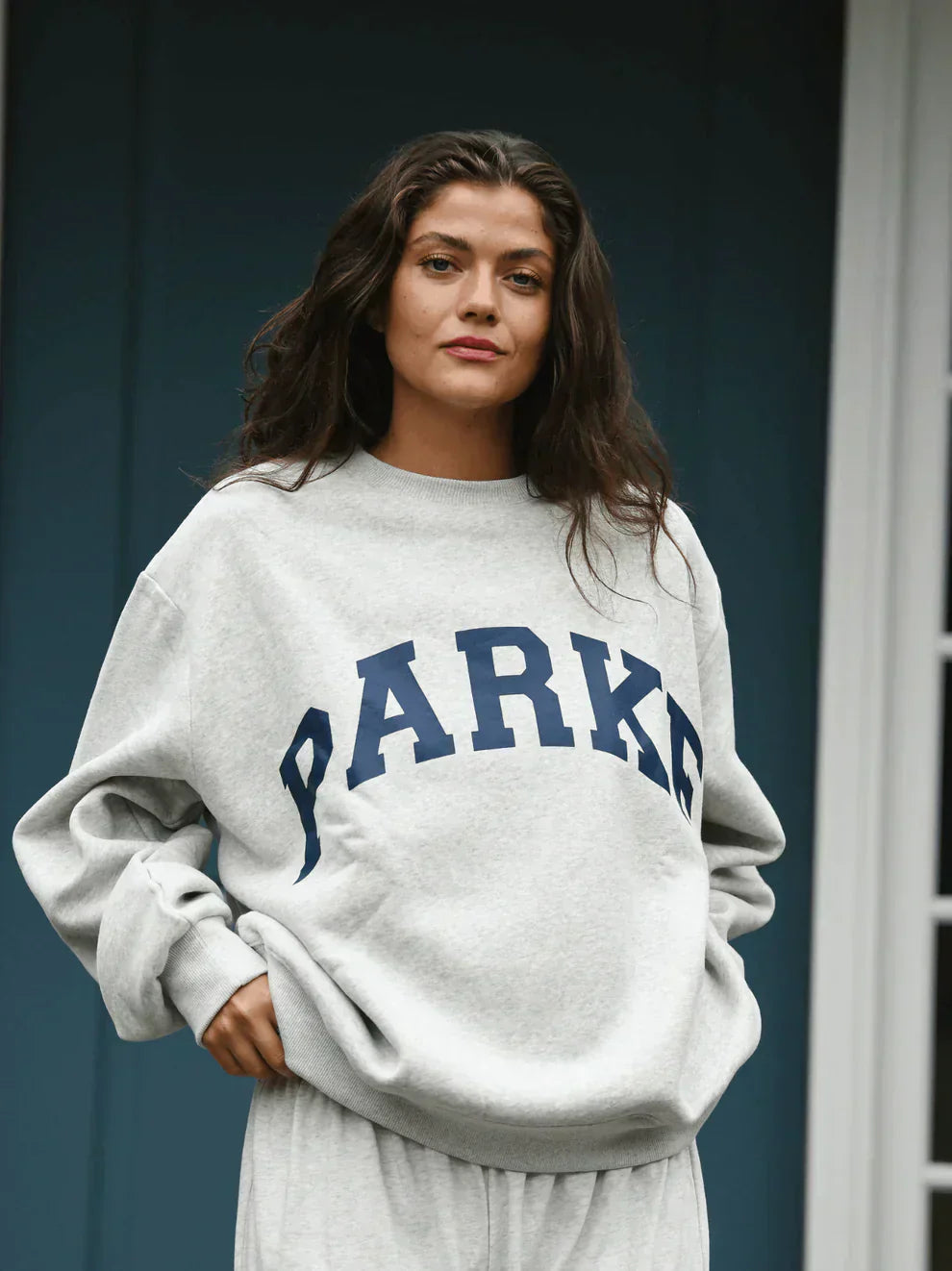 Women's varsity sweatshirt styled with casual bottoms for everyday collegiate look