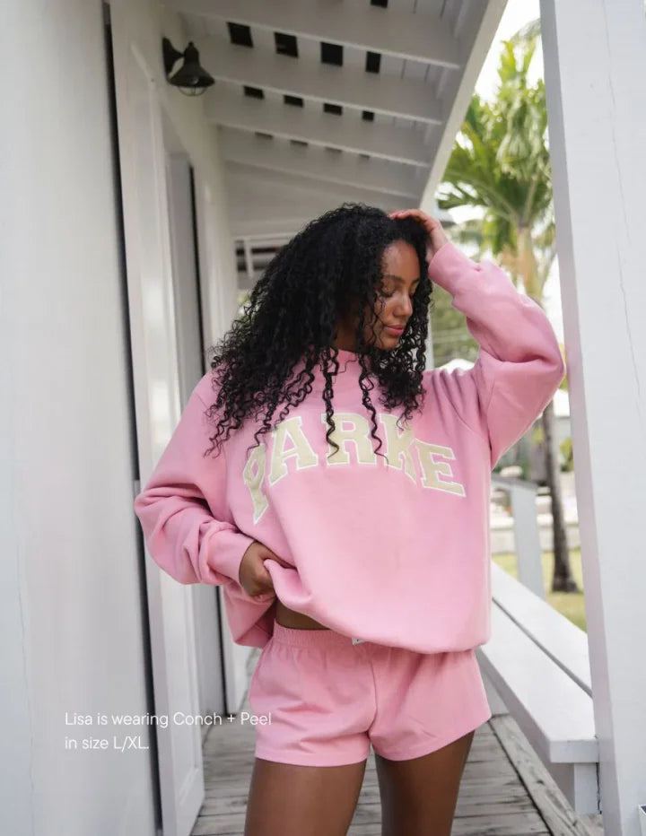 Detail of ribbed crewneck and cuffs on oversized varsity fleece sweatshirt