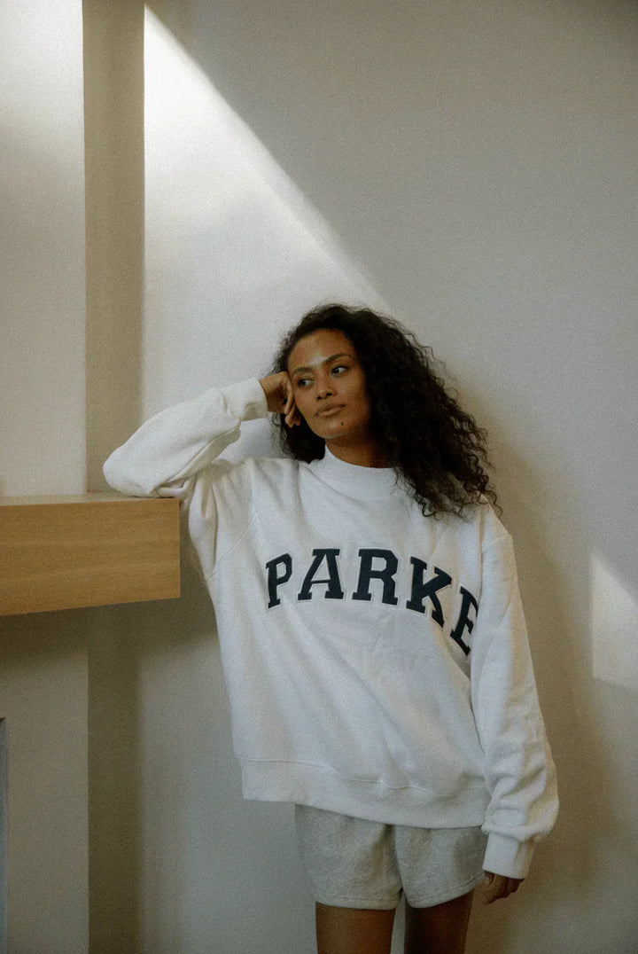 Grey oversized varsity sweatshirt with navy chenille lettering and ribbed details