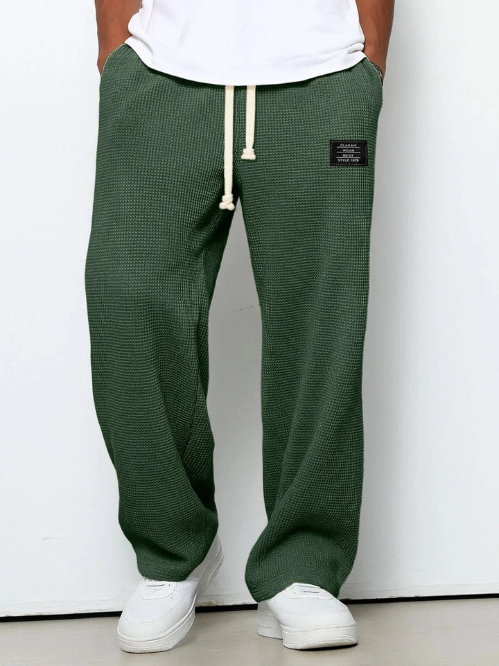 Full length view of men's waffle textured joggers with white sneakers