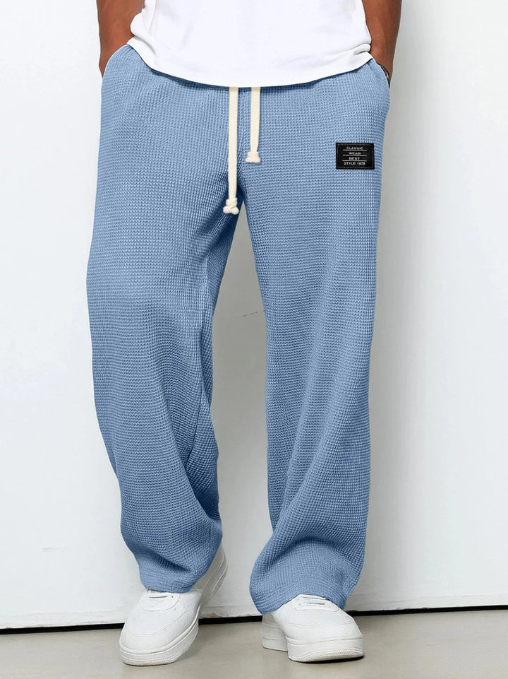 Sky blue waffle textured joggers with adjustable drawstring waist and patch detail at hip