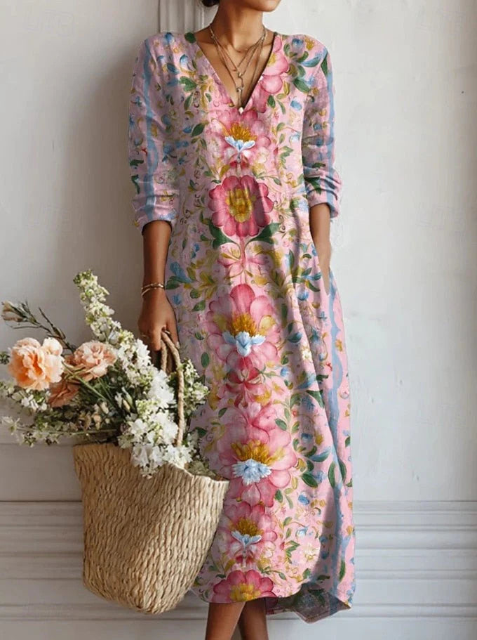 Woman wearing a floral V-neck midi summer cotton dress with pink and blue blooms and 3/4 sleeves