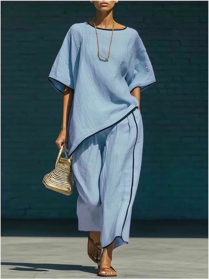 Woman wearing light blue linen cropped pant set with loose short sleeve top and wide leg pants