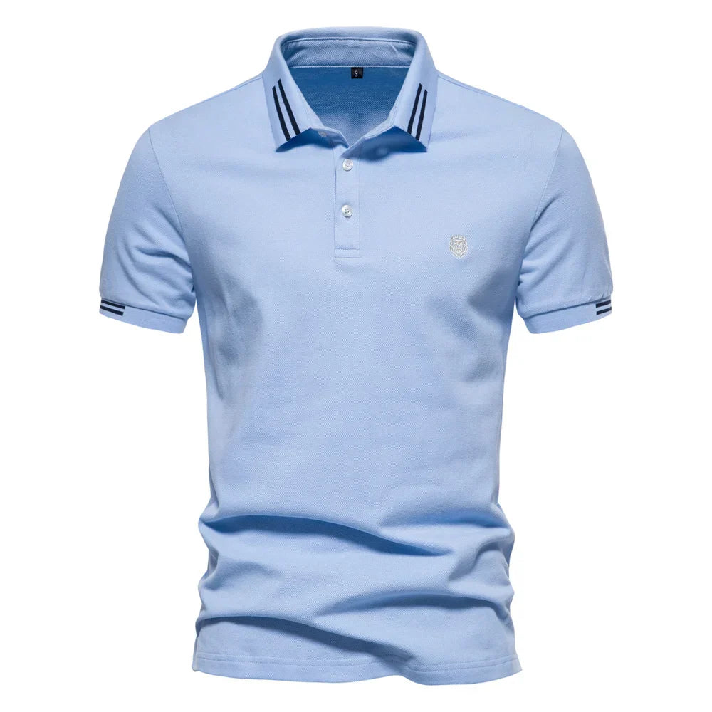 Detail shot of embroidered logo on chest of men's stripe trim polo shirt