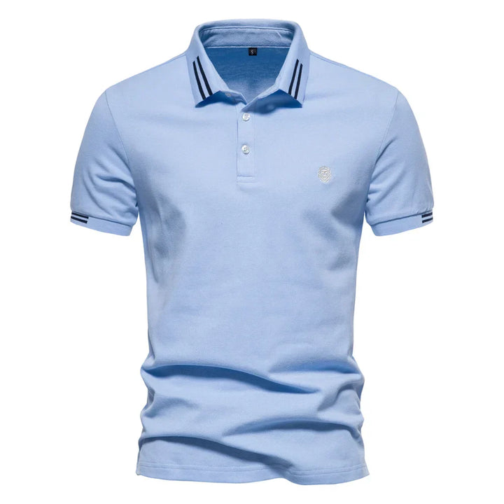 Detail shot of embroidered logo on chest of men's stripe trim polo shirt