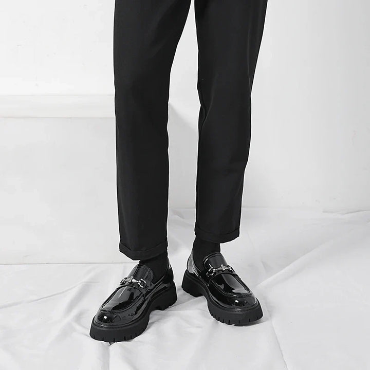 Black leather dress loafers for women showing chunky lug sole and structured silhouette