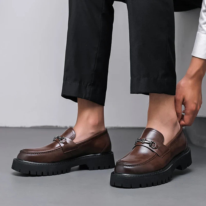 Women's leather dress loafers in brown resting on books showing lug sole traction