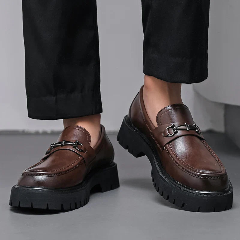 Front angle of brown leather dress loafers with slip-on construction and buckle detail