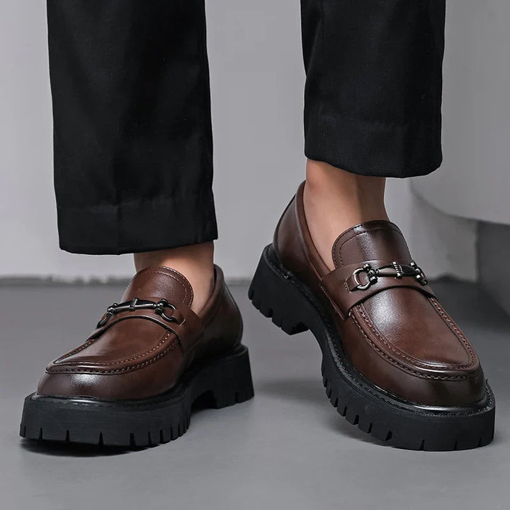 Front angle of brown leather dress loafers with slip-on construction and buckle detail